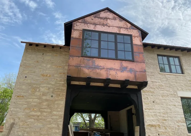 Copper metal panel facade on a stone building for Skylight Installation in Lake Hallie